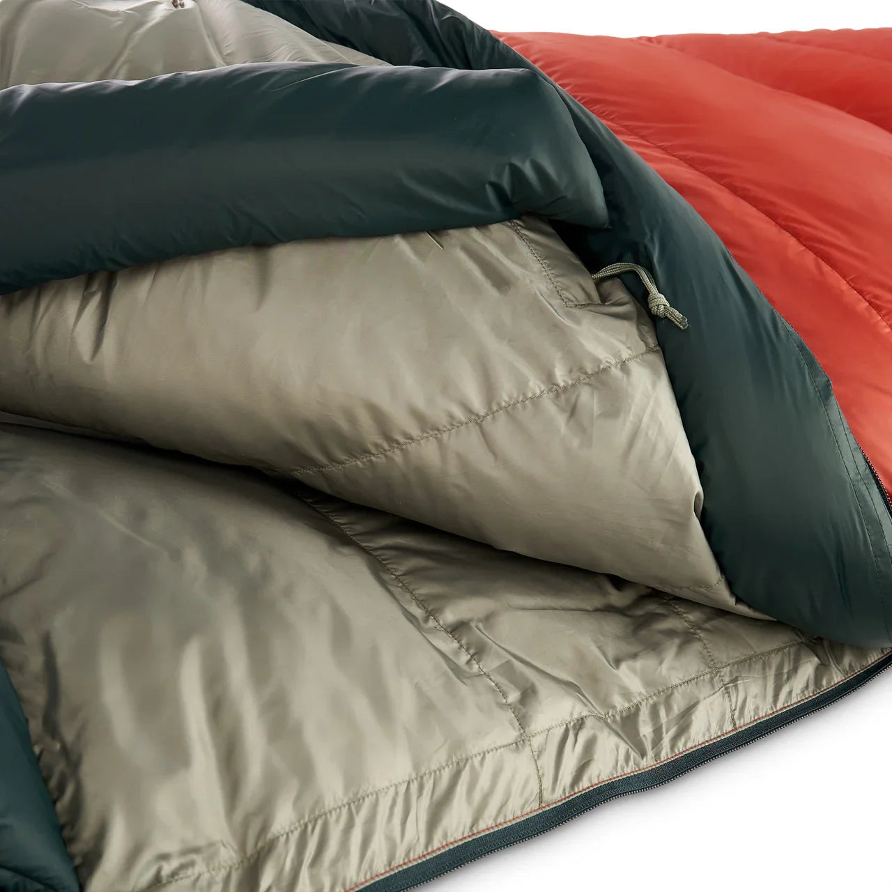 Close-up of Kelty Cosmic Down sleeping bag with red, green, and beige quilted fabric