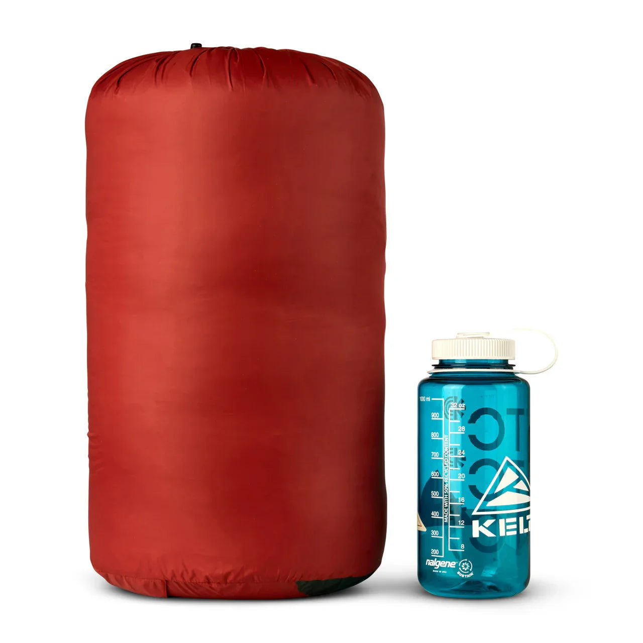 Red Kelty Cosmic Down sleeping bag in stuff sack beside blue Kelty Nalgene bottle