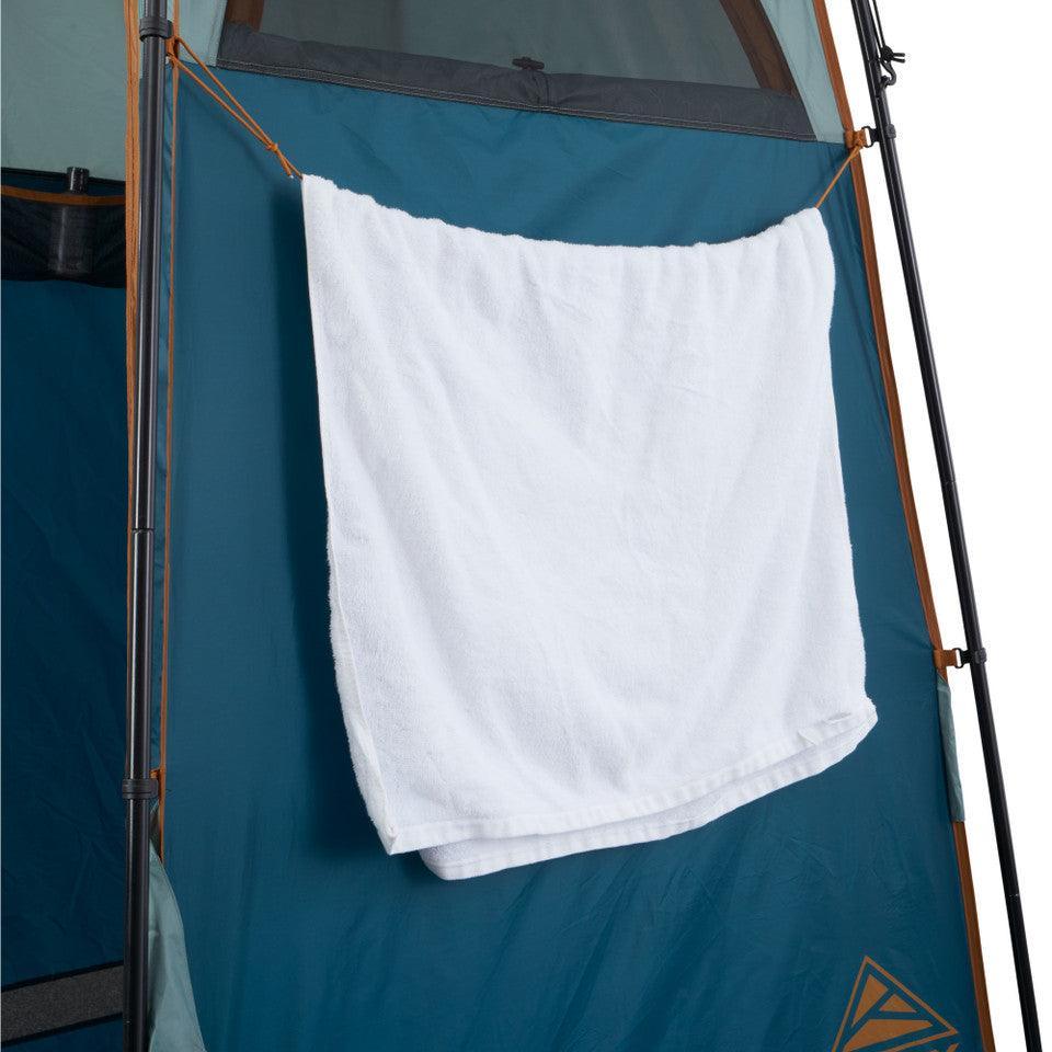 White towel hanging on a teal tent exterior, outdoor camping gear setup