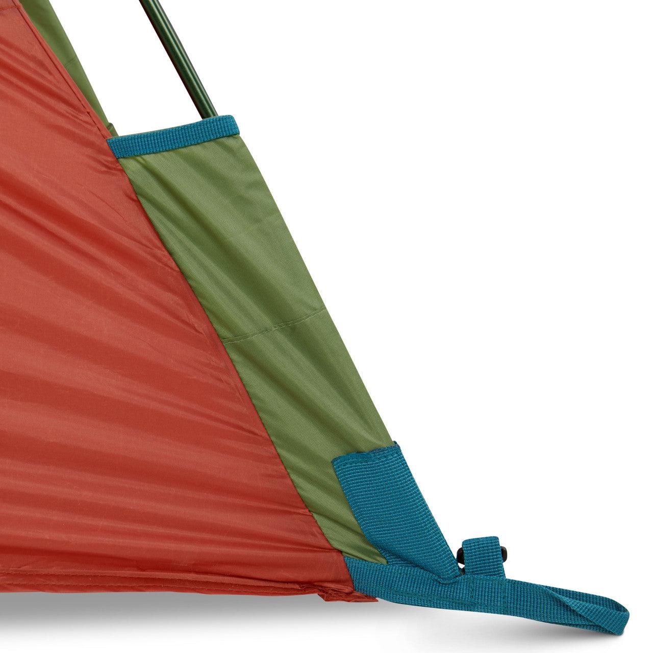 Close-up of green and red tent corner with blue strap and reinforced seams