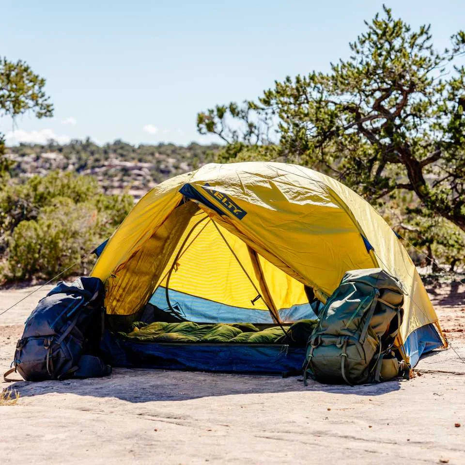 Kelty Far Out 2 yellow camping tent with footprint, two backpacks, pitched outdoors