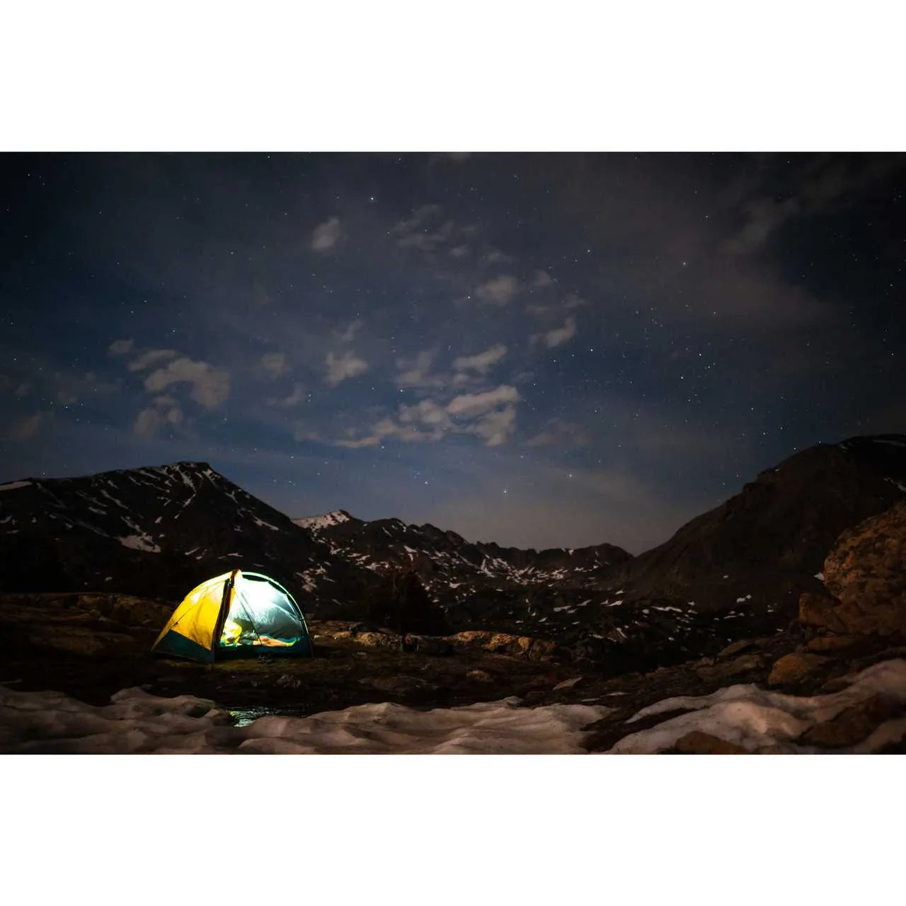 Kelty Far Out 2 tent with footprint glowing at night in snowy mountain landscape