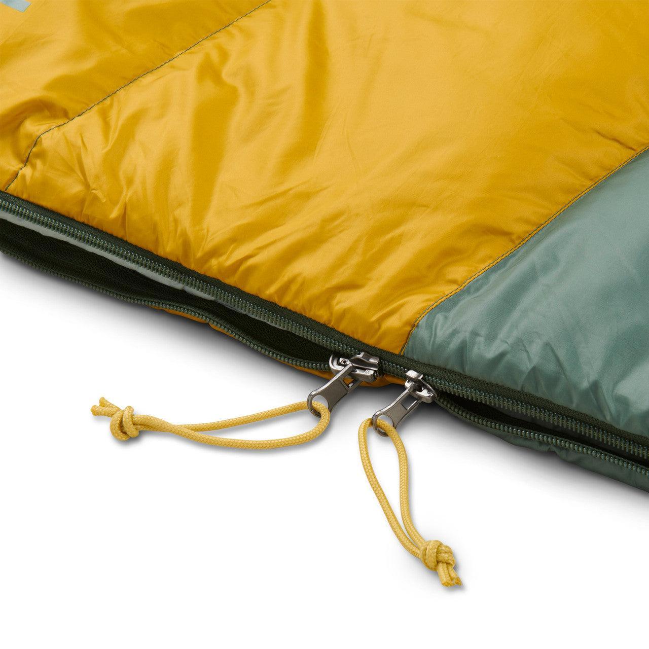 Close-up of yellow and green sleeping bag with two-way zipper and drawstring pulls
