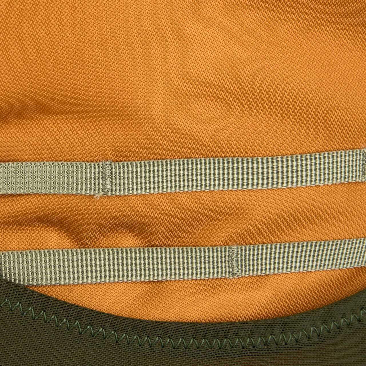 Close-up of Kelty Glendale 65L backpack orange fabric with green webbing straps