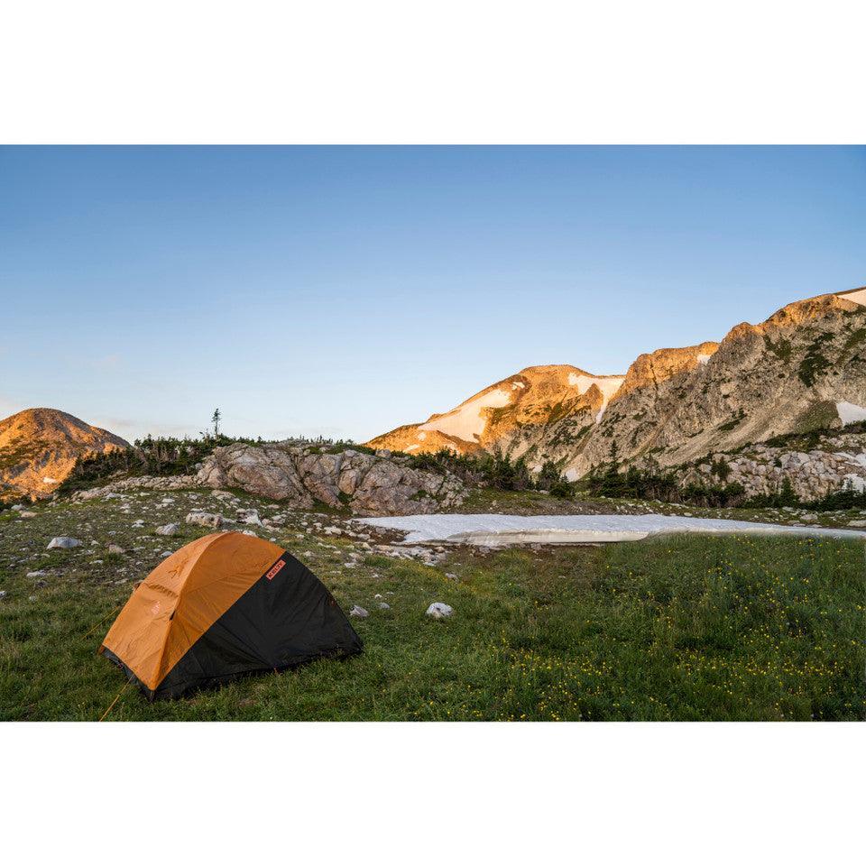 Kelty Grand Mesa 2 backpacking tent pitched on grassy mountain landscape at sunset