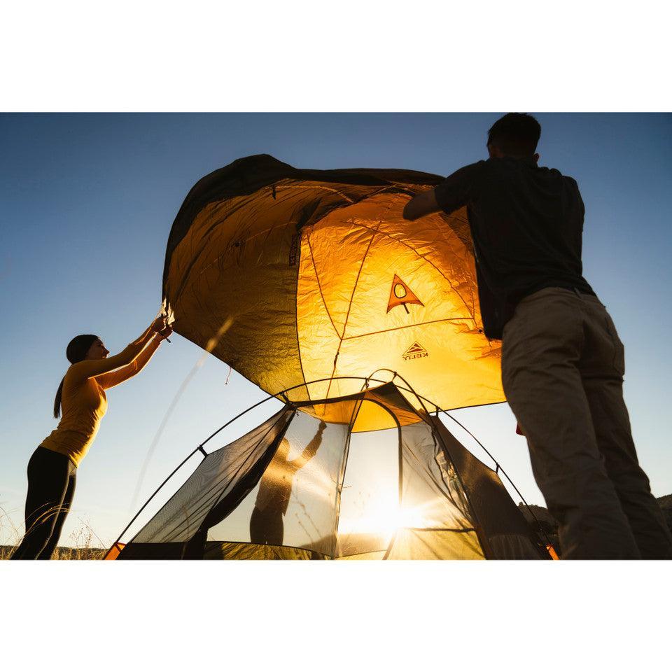 Two people setting up a Kelty Grand Mesa 2 backpacking tent at sunset outdoors