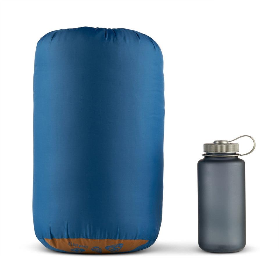 Blue camping stuff sack next to gray water bottle on white background