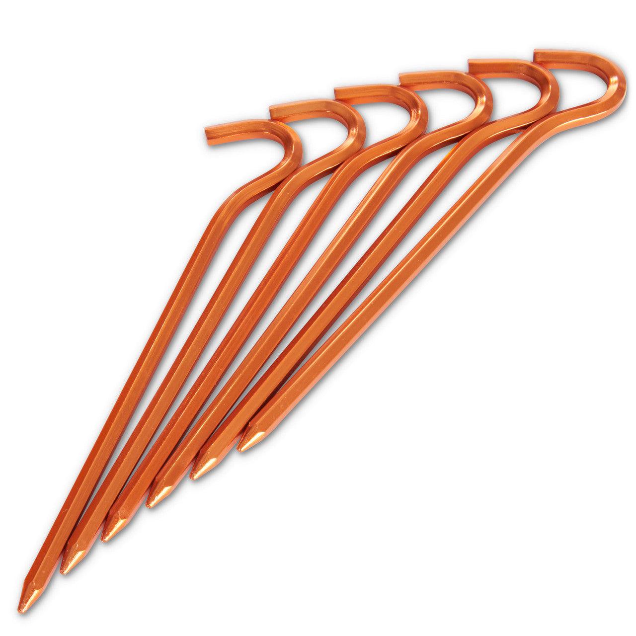 Set of six orange metal tent stakes with hook tops on white background
