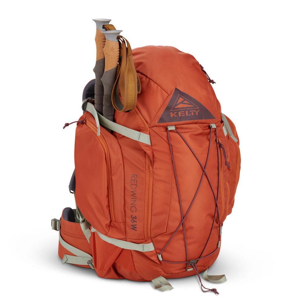 Kelty Redwing 36W women's orange hiking backpack with trekking poles attached