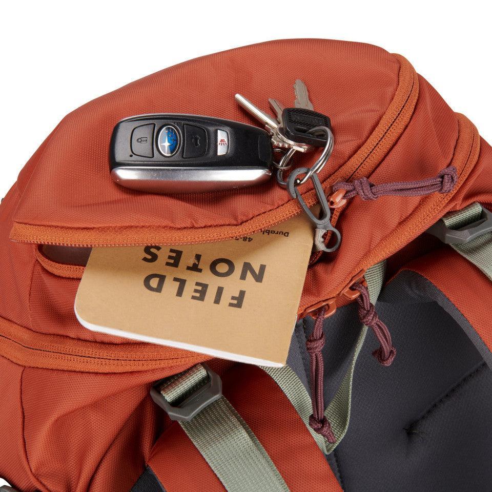 Rust orange Kelty Redwing 36 womens backpack pocket with keys and Field Notes notebook visible