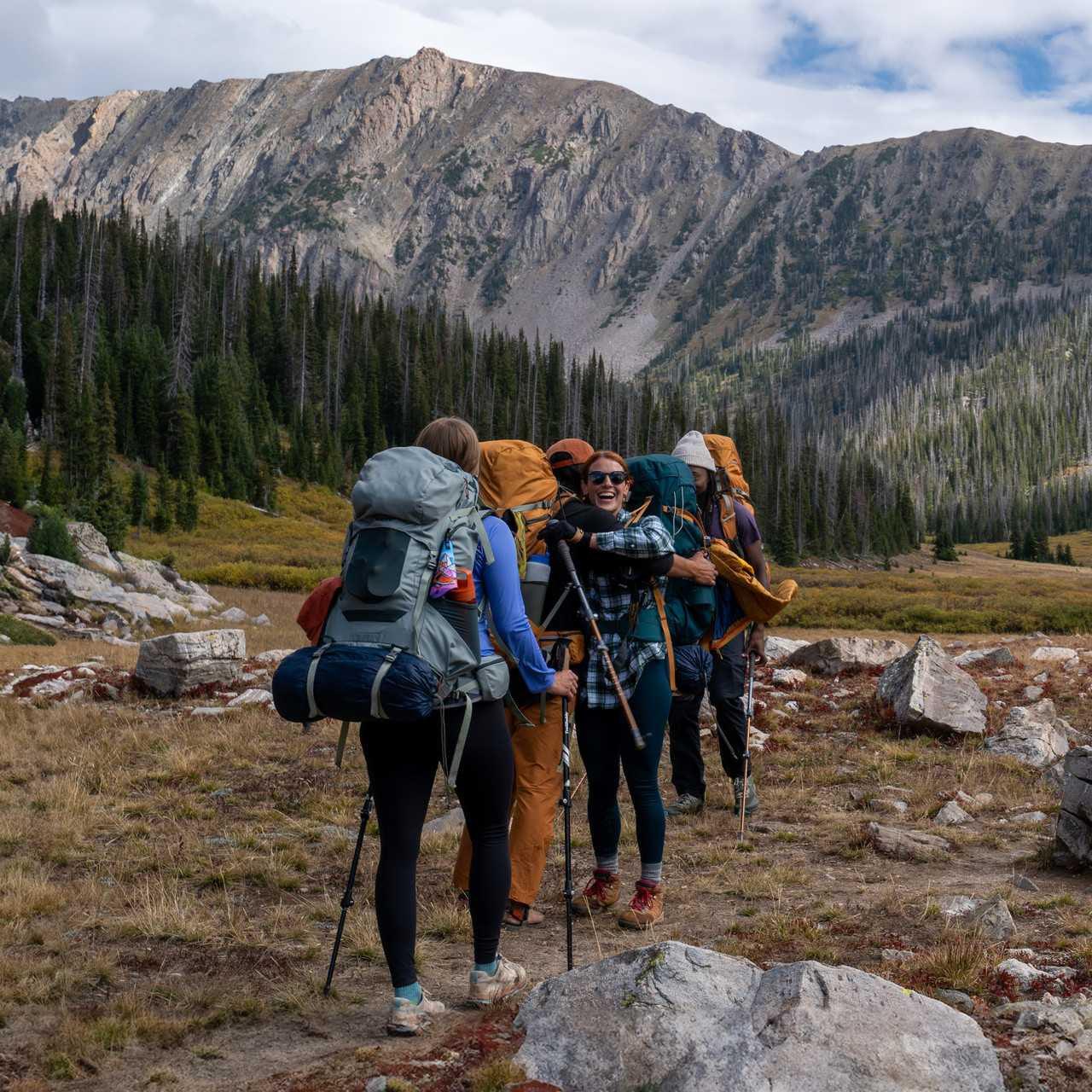 Women hiking in mountains with Kelty Glendale 65L backpacks and trekking poles