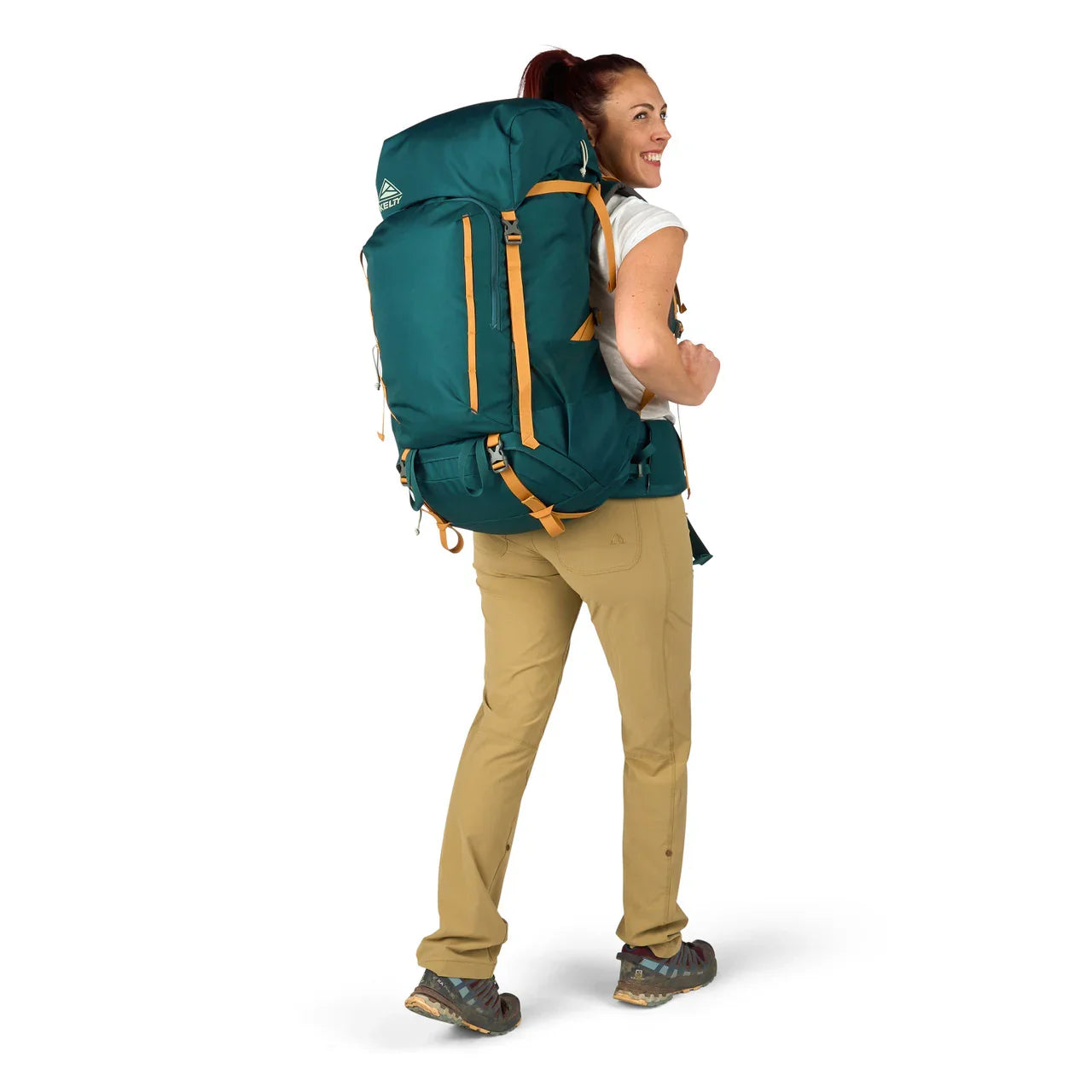 Woman wearing Kelty Nena 65L deep teal hiking backpack, khaki pants, trail shoes