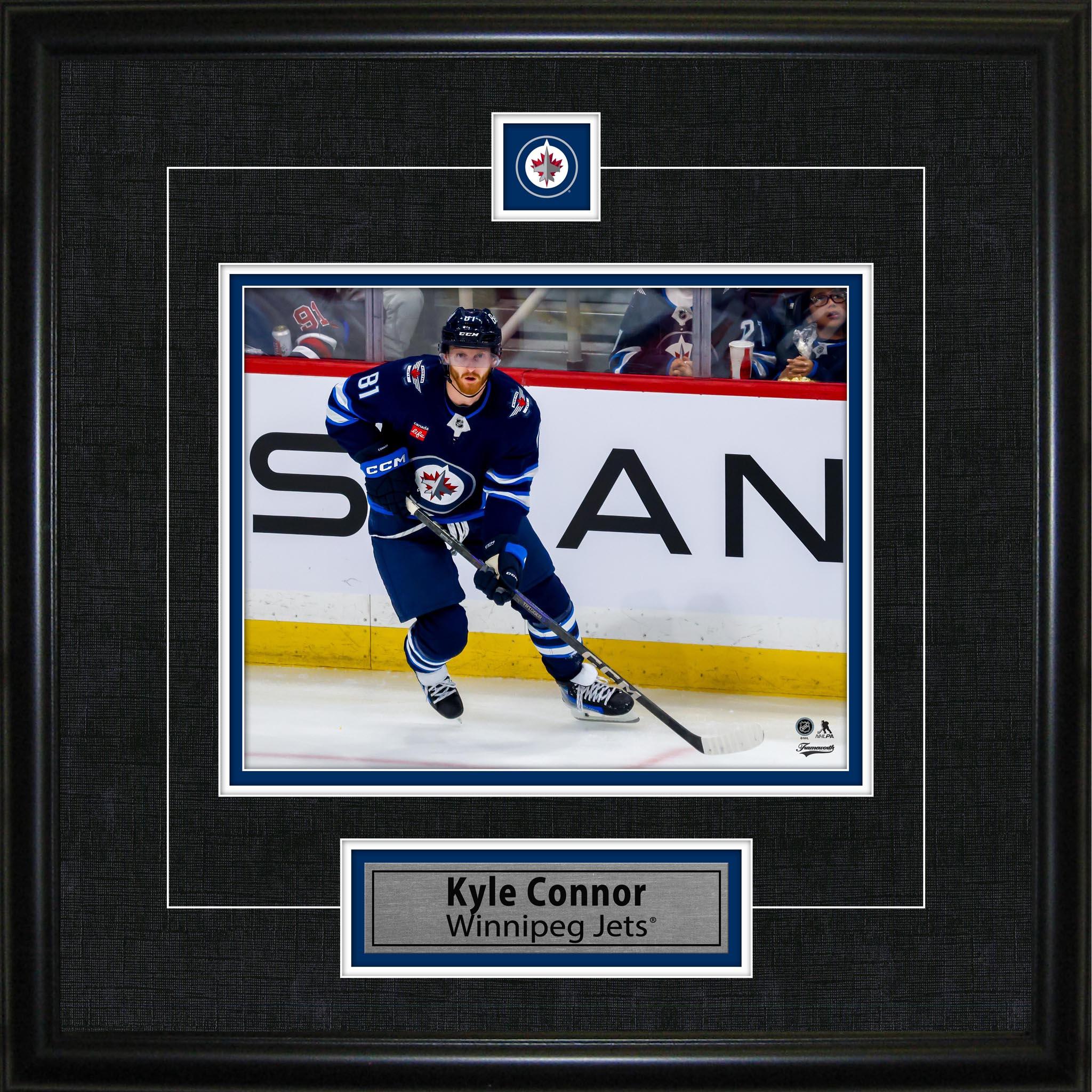 Framed photo of Winnipeg Jets hockey player in blue jersey skating on ice, labeled Kyle Connor.
