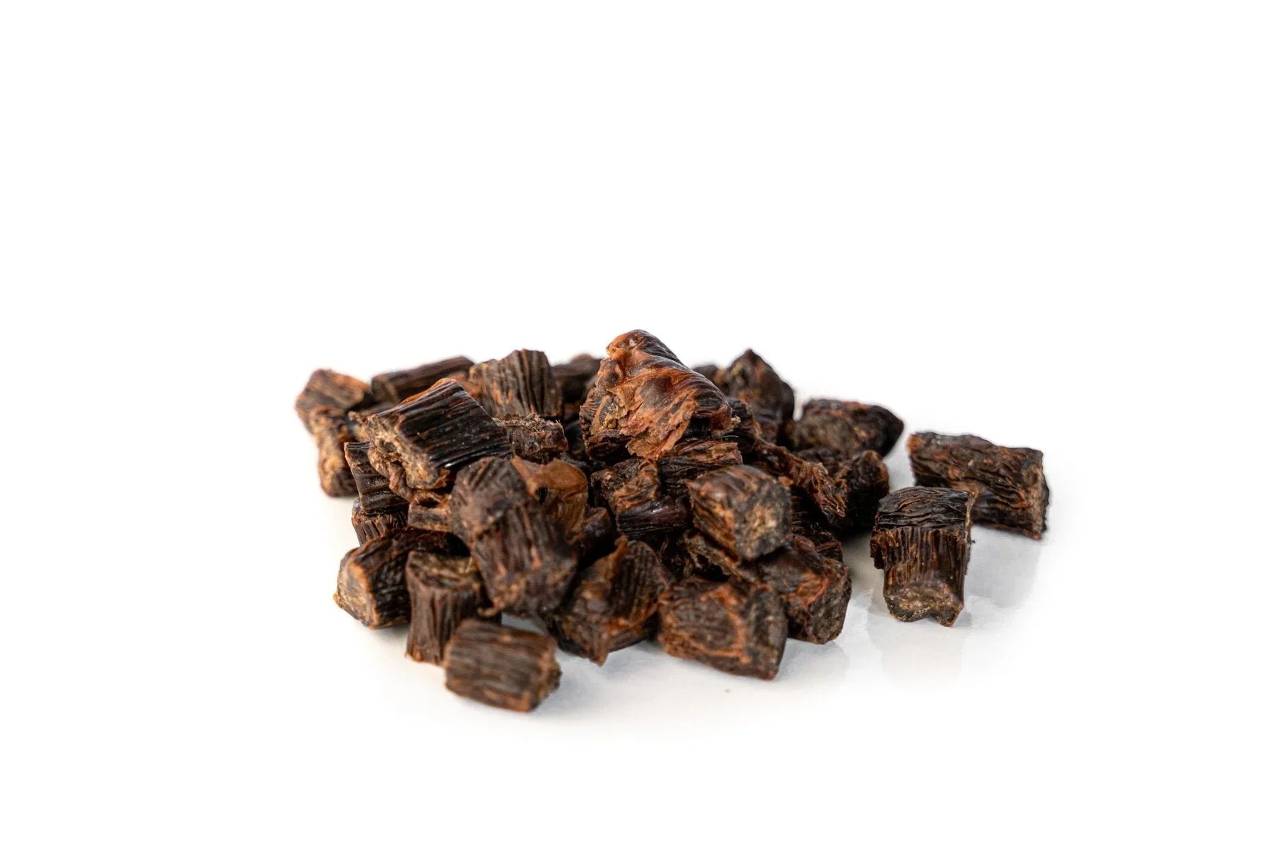 Lamb tripe bites dog treats, dark brown cubes on white background