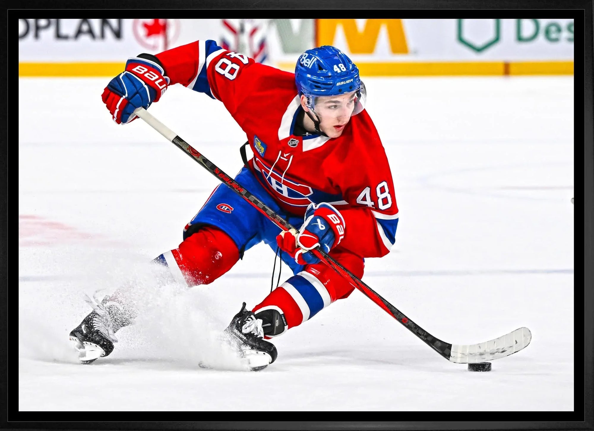 Montreal Canadiens hockey player in red jersey and helmet skating on ice during game