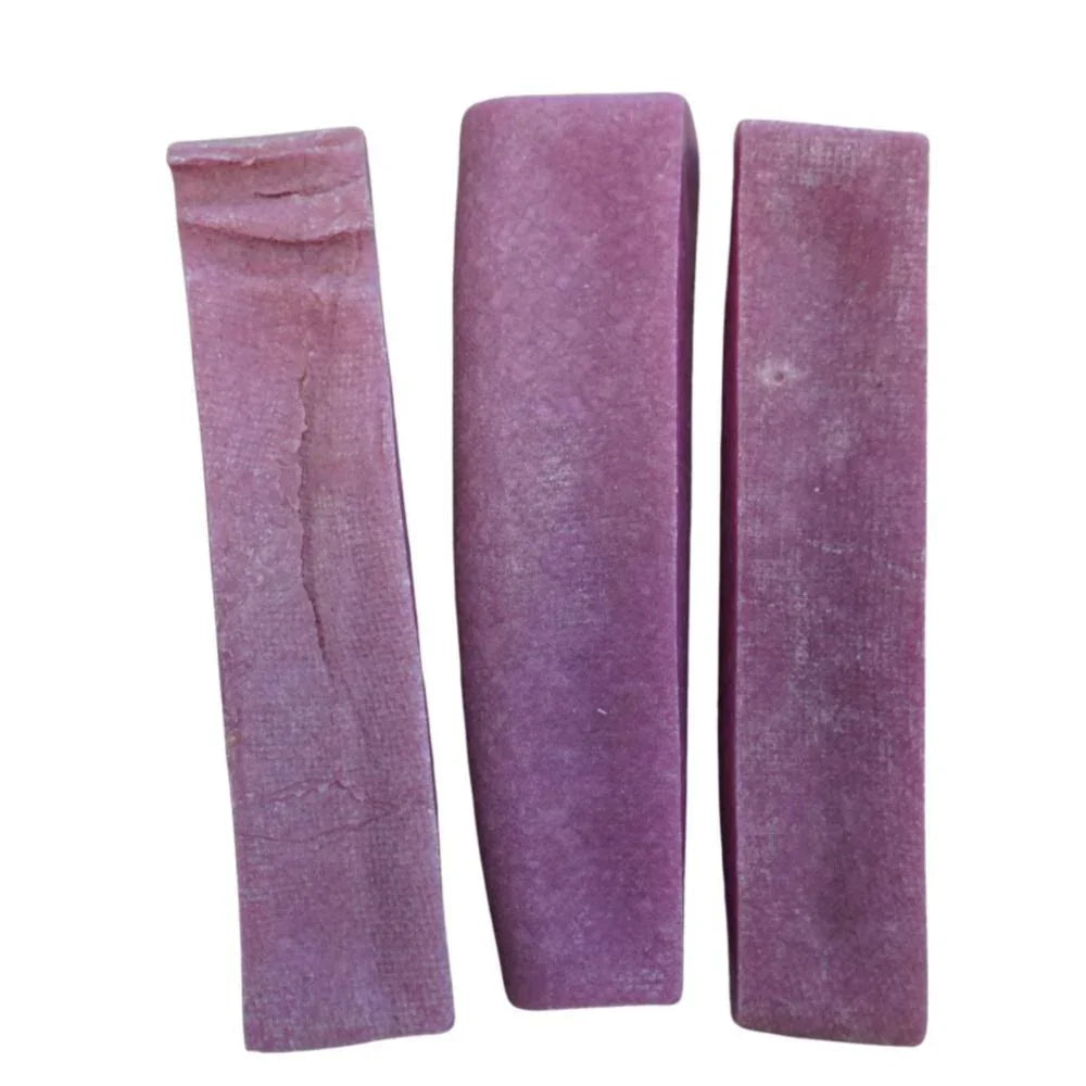 Three large purple blueberry Himalayan yak chews on a white background