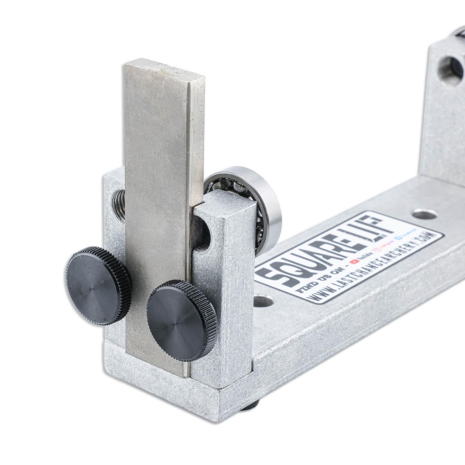 Archery squaring tool with metal frame, adjustment knobs, and labeled base.
