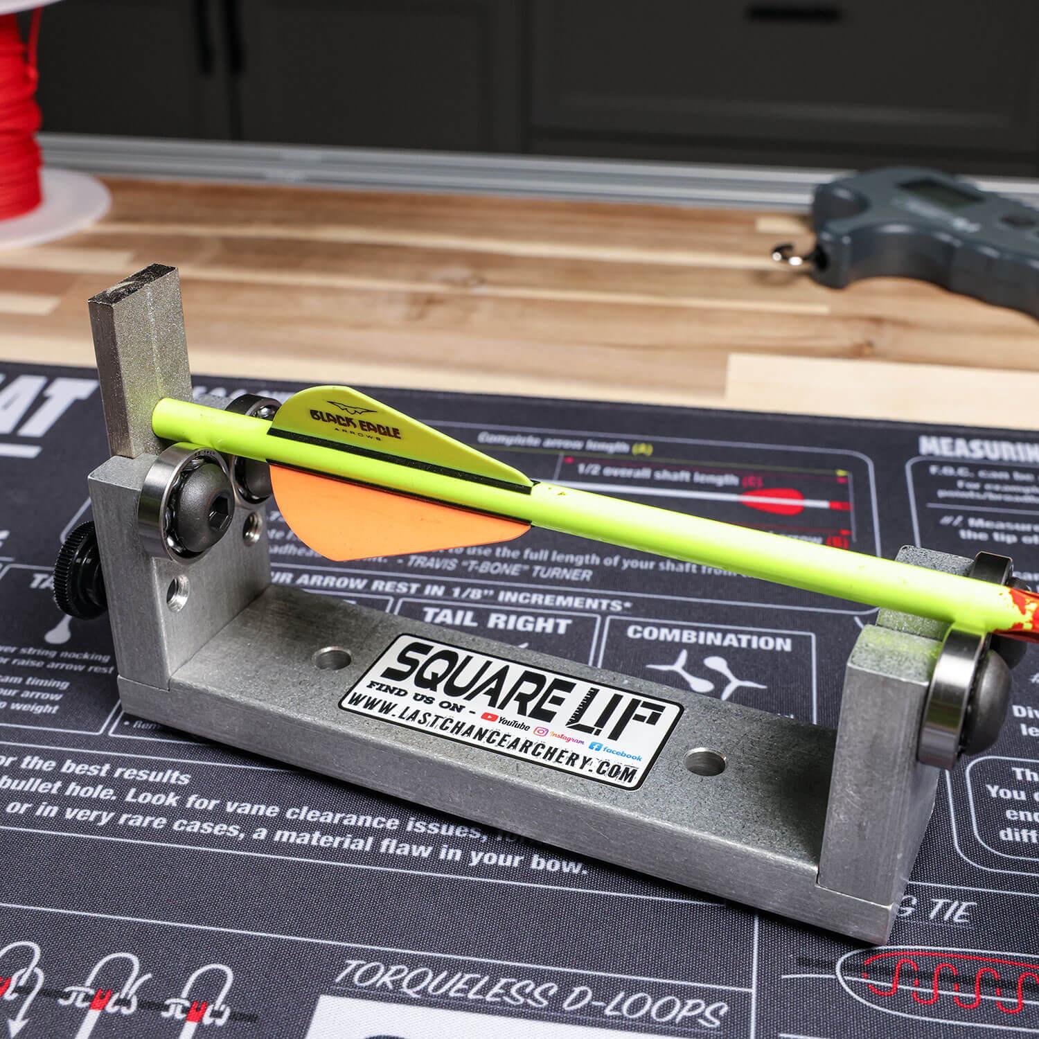 Archery squaring tool with yellow Black Eagle arrow on Last Chance Archery work mat