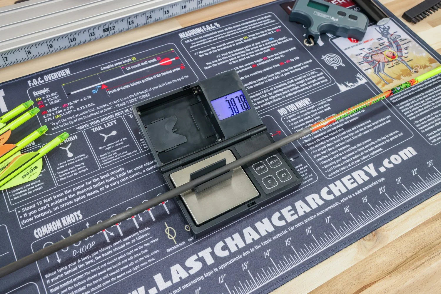Archery arrow on digital scale with arrows and tools on Last Chance Archery setup mat