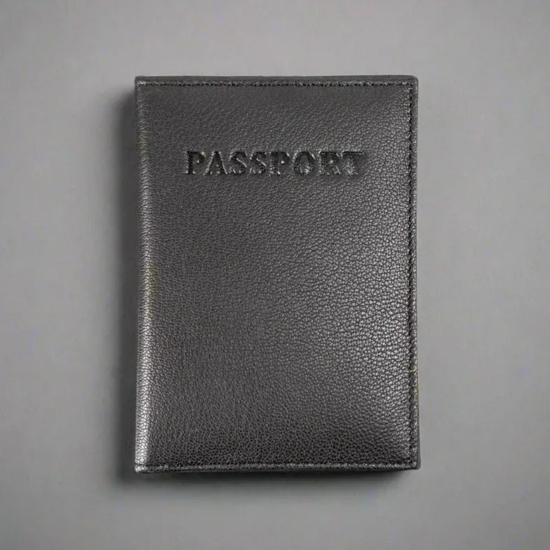 Black leather passport holder with embossed text on gray background