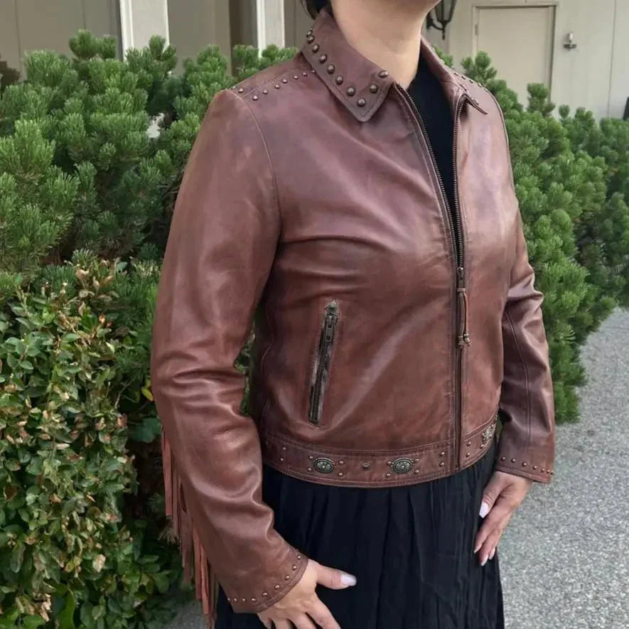 Brown leather western jacket with fringe and studs worn by woman outdoors