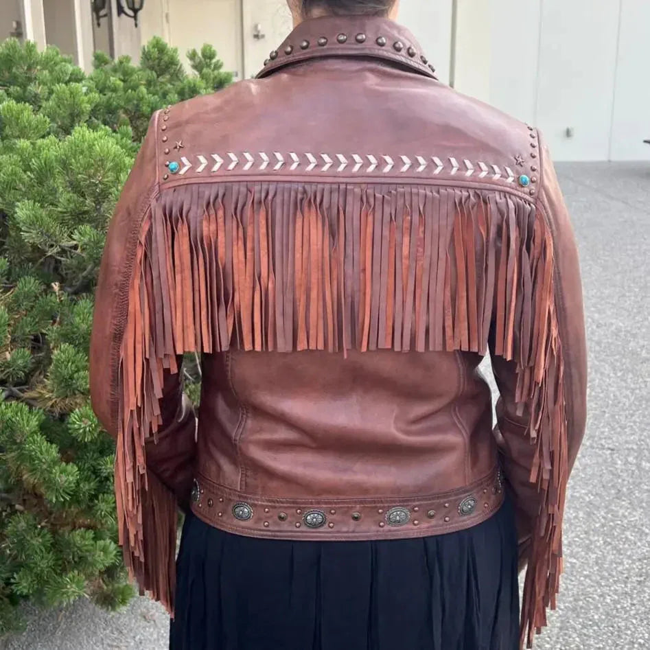 Brown leather western jacket with fringe and metal studs, seen from the back outdoors