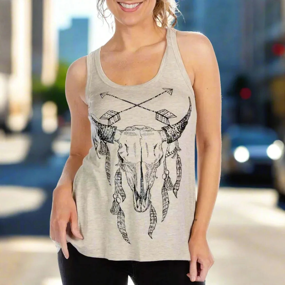Woman wearing Liberty Wear Cody tank top with bull skull and feather graphic, city background