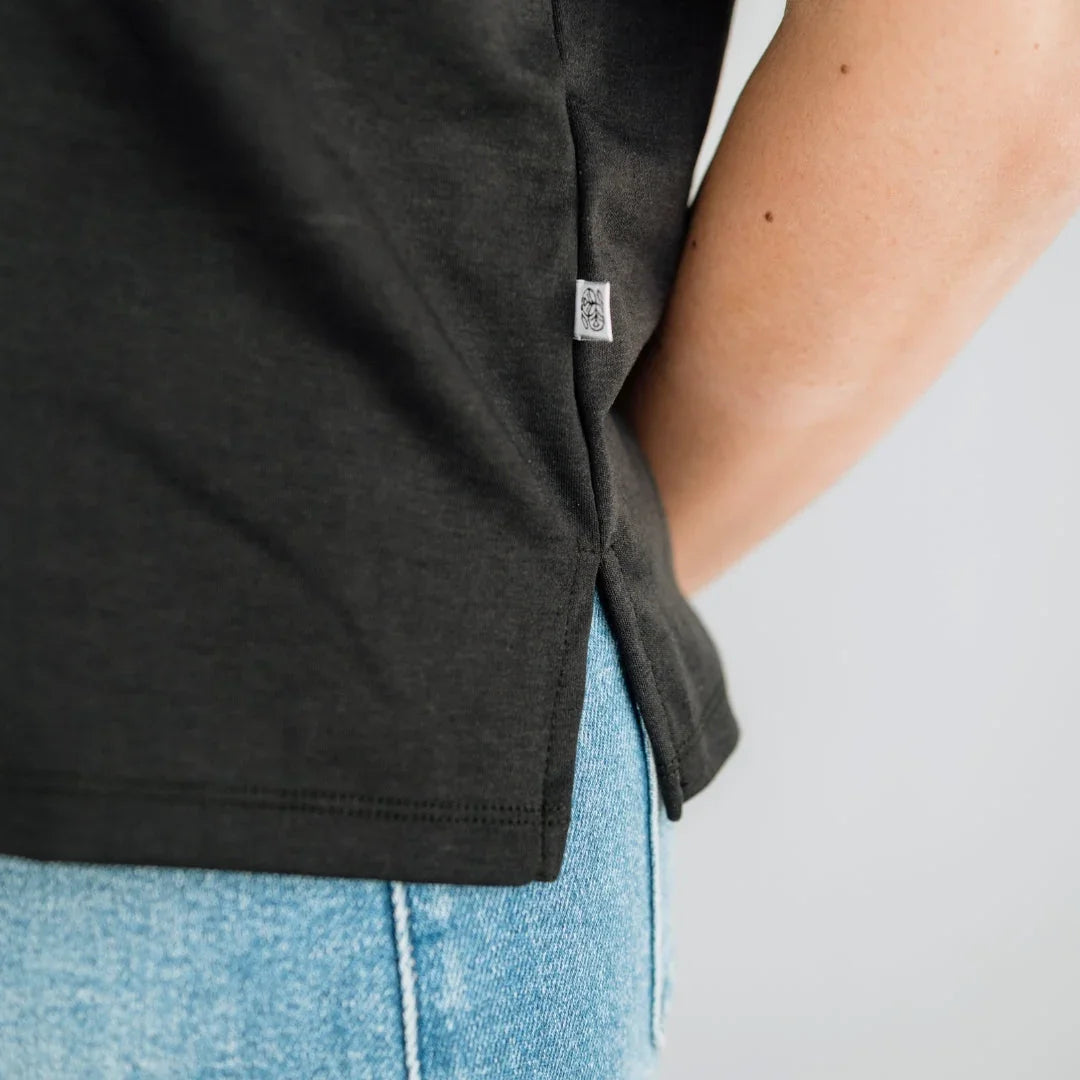 Black t-shirt with side tag and blue denim jeans close-up