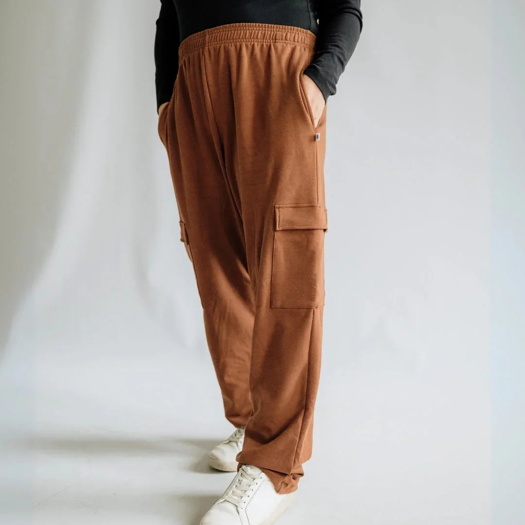 Brown cargo jogger pants with side pockets, white sneakers, and black top on model