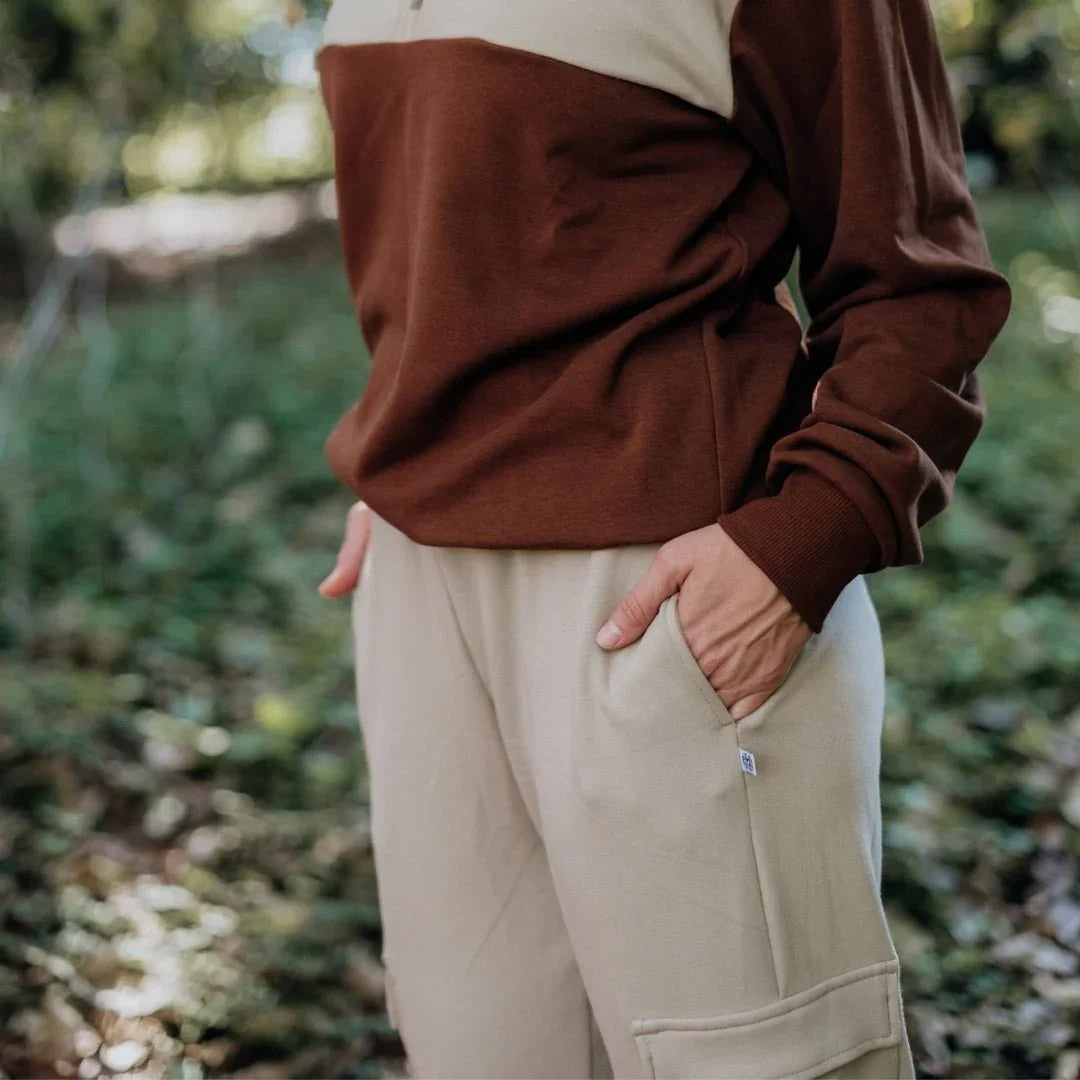 Woman wearing beige bamboo fleece cargo pants and brown sweatshirt outdoors