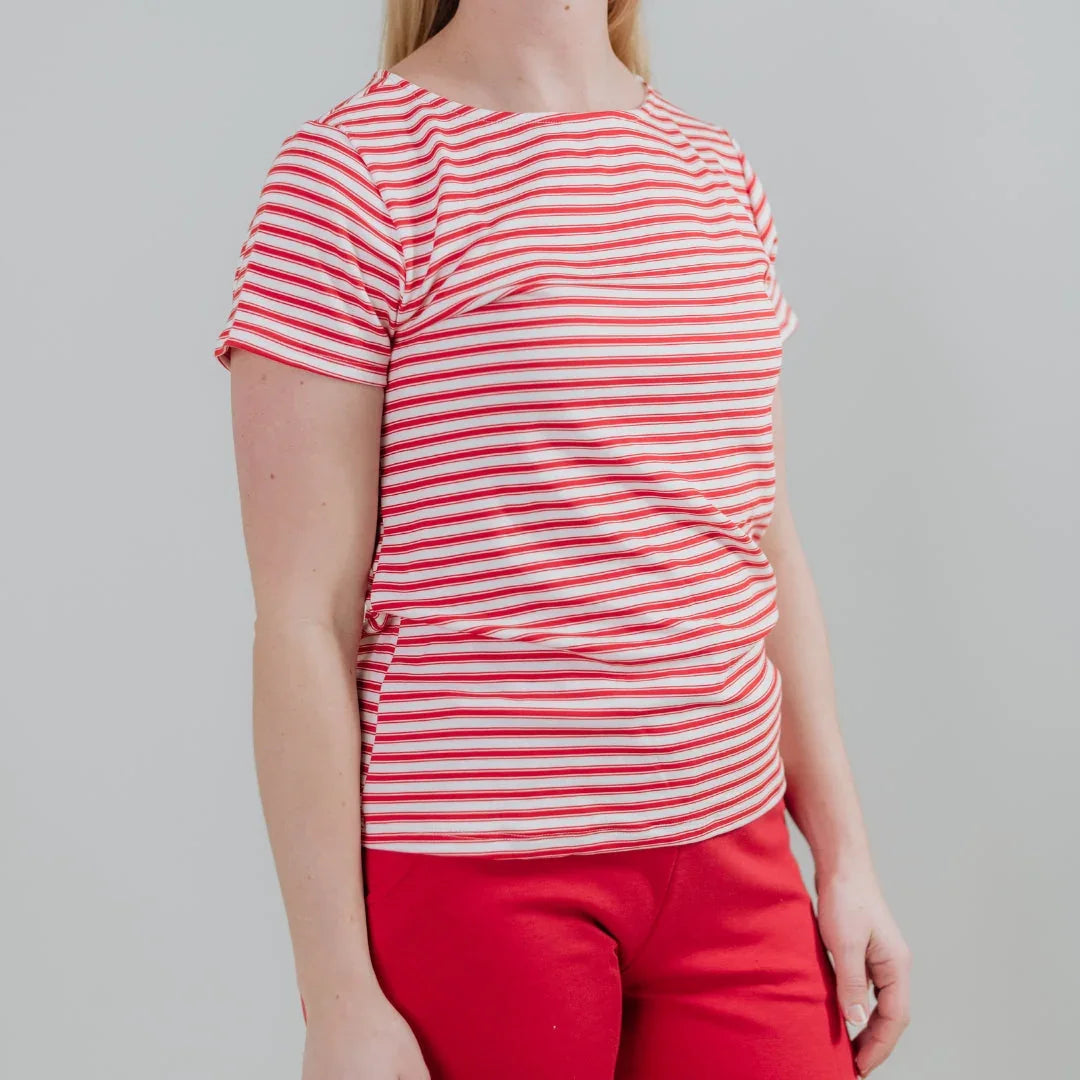 Woman wearing red and white striped t-shirt and red pants on plain background