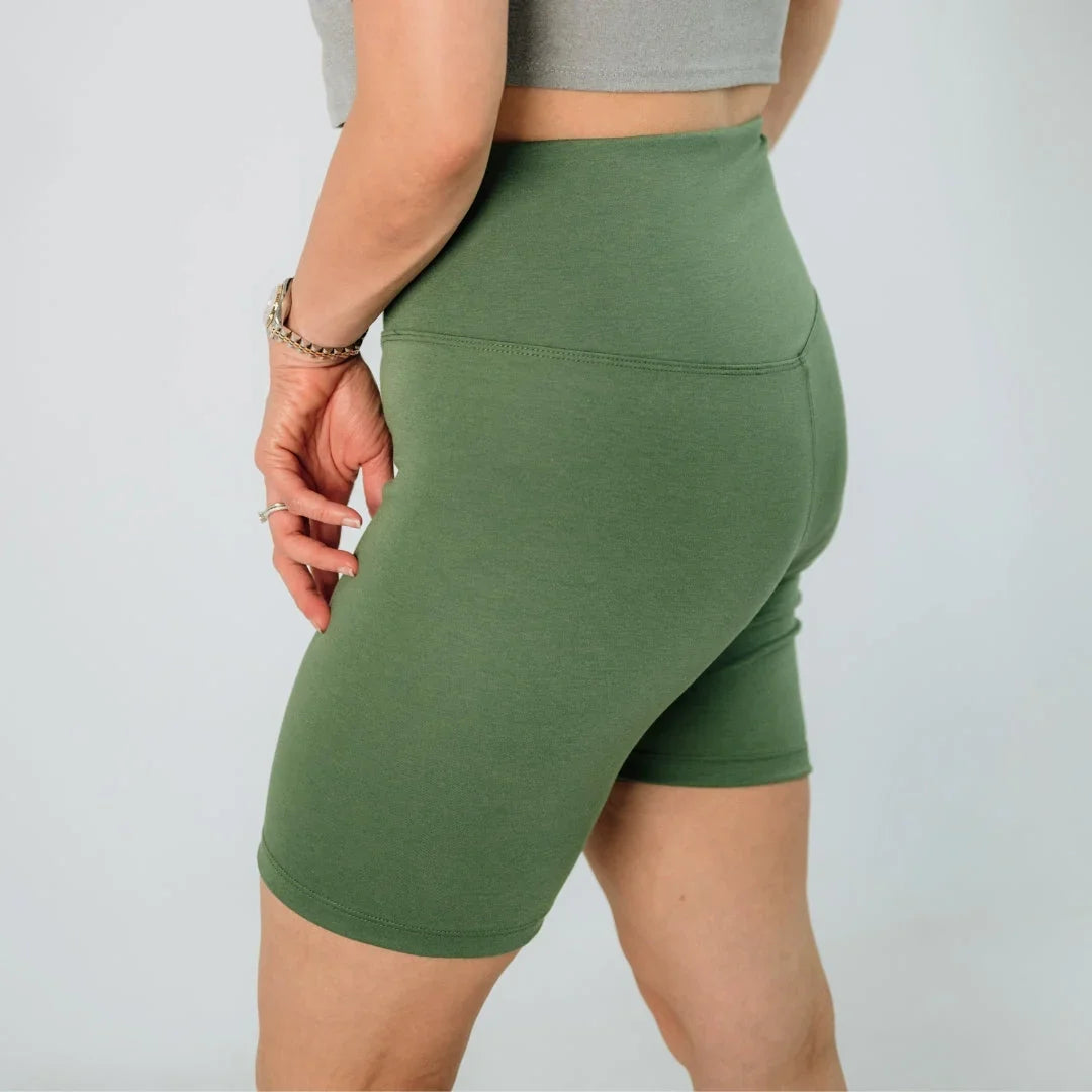 Woman wearing high-waisted green bike shorts, activewear fashion close-up