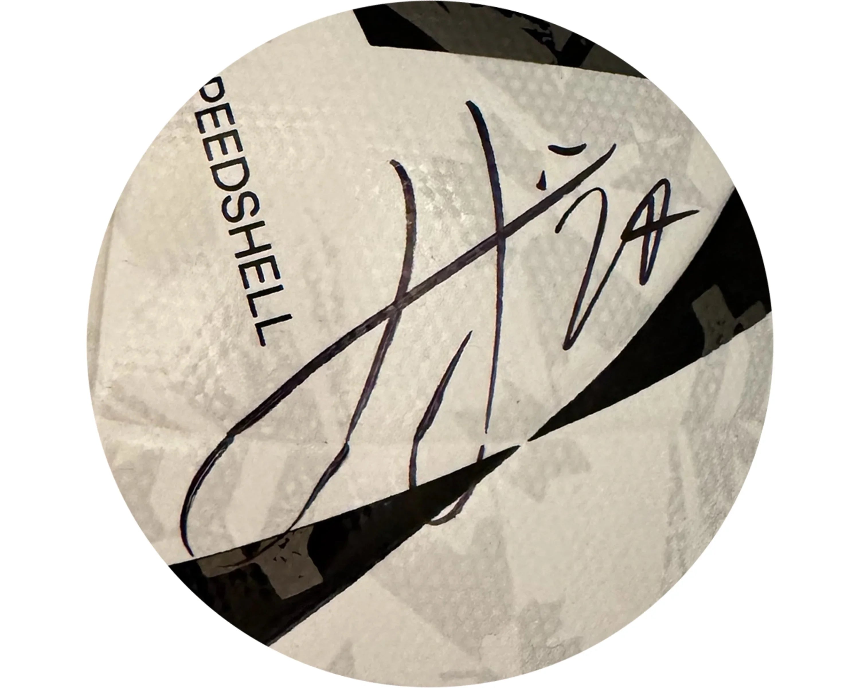 Close-up of a signed white soccer ball with text 'SPEEDSHELL' and black geometric accents