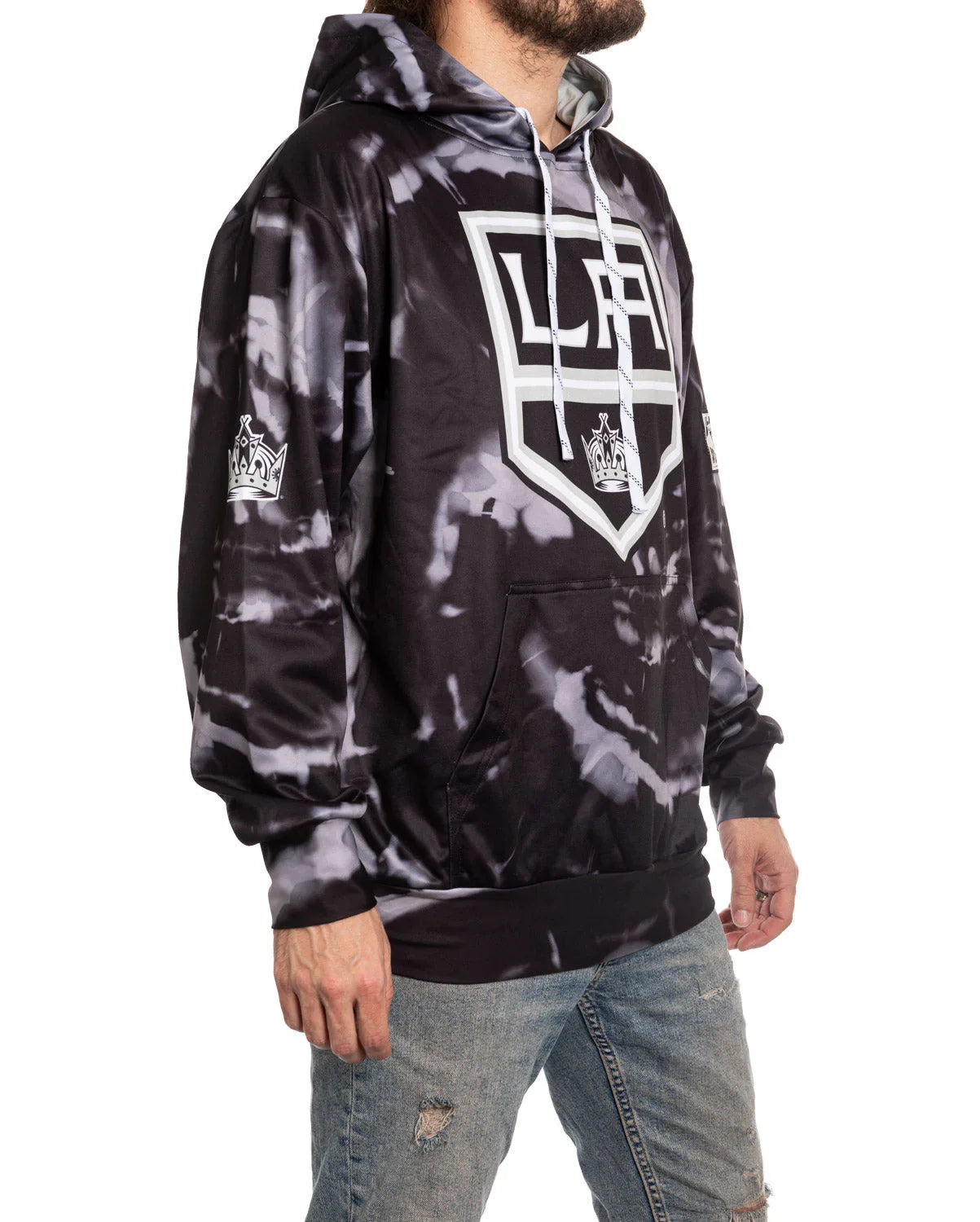 Man wearing black LA Kings tie-dye hoodie with logo and distressed jeans