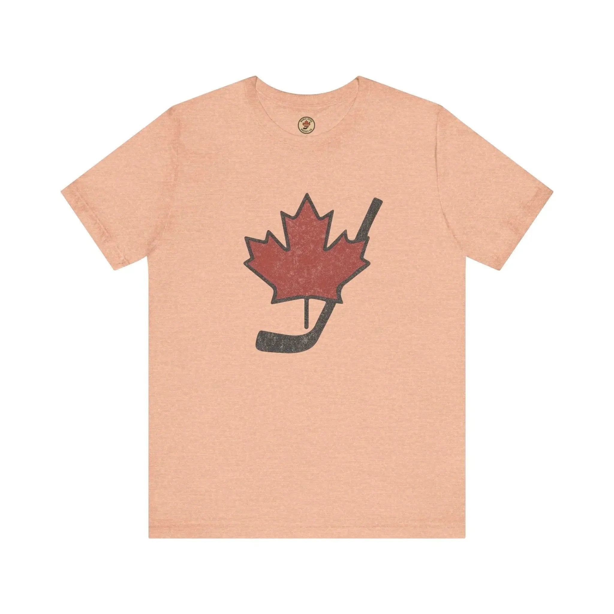 Peach t-shirt with red maple leaf and black hockey stick graphic, Canadian sports shirt