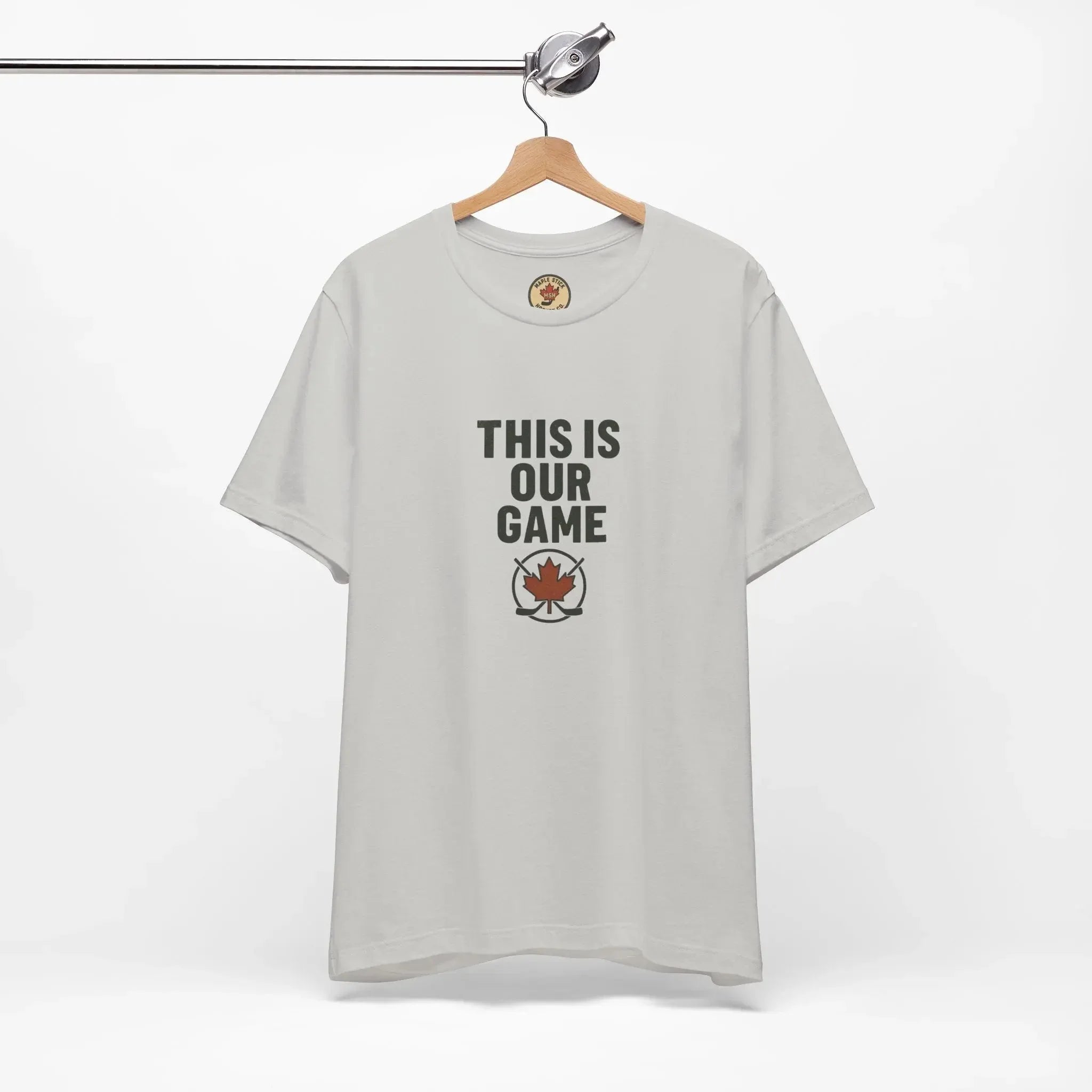 White t-shirt on hanger with 'THIS IS OUR GAME' text and red maple leaf hockey logo