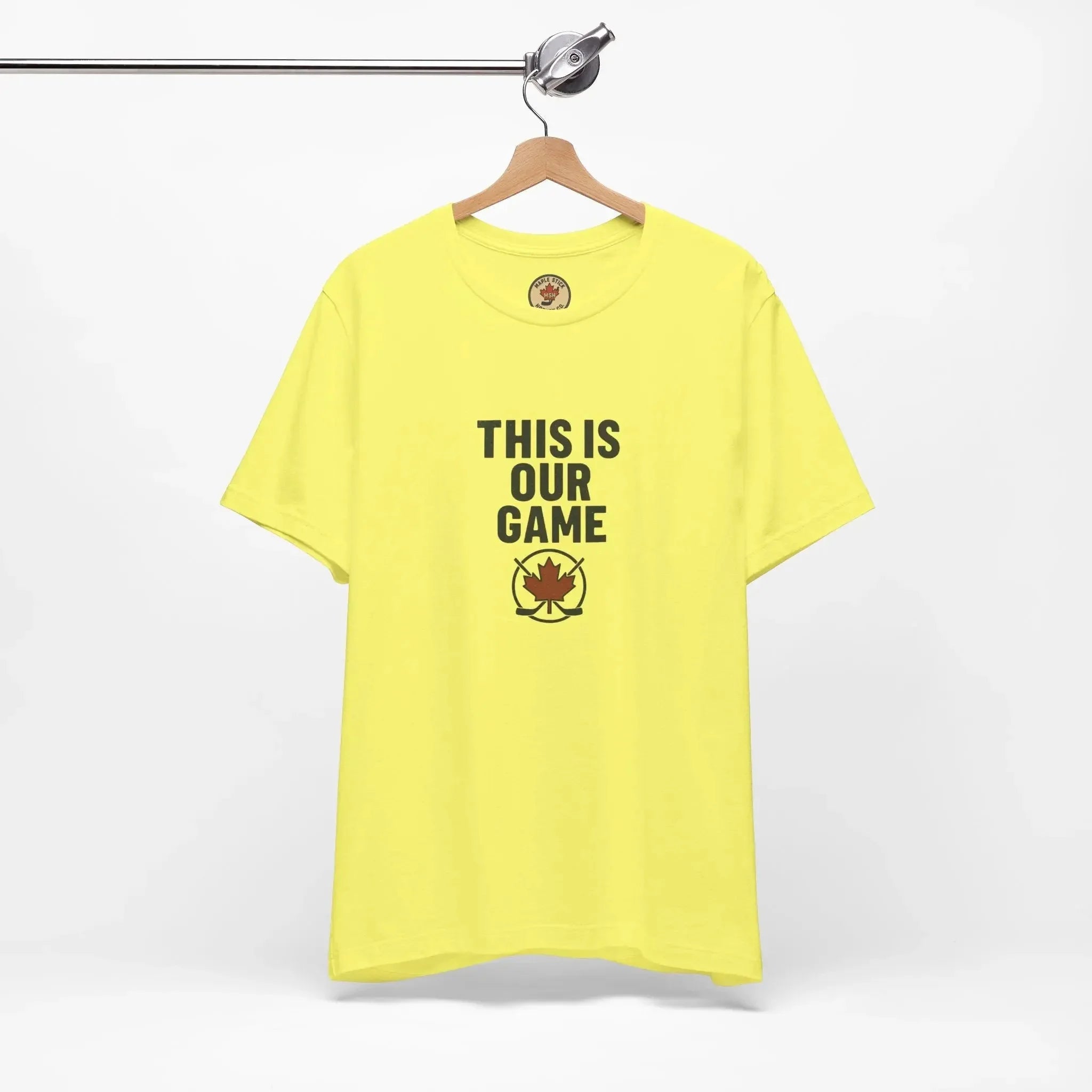 Yellow t-shirt with 'This Is Our Game' and maple leaf hockey logo on hanger