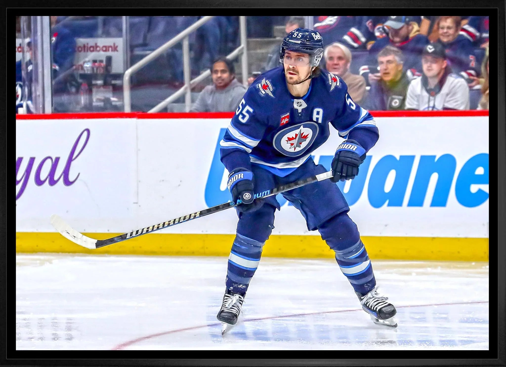 Winnipeg Jets player in blue jersey skating on ice during hockey game