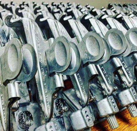 Stack of industrial metal clamps arranged in rows, tool hardware close-up