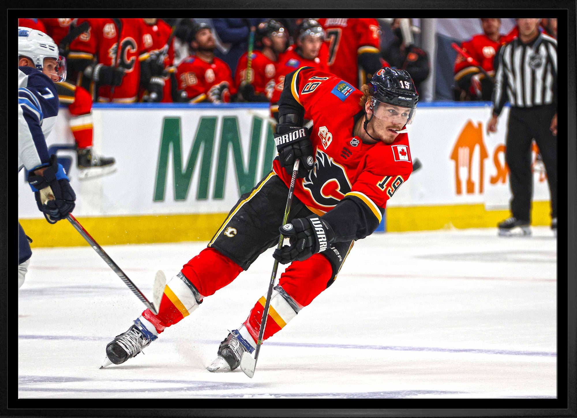 Calgary Flames hockey player in red jersey skating on ice during game