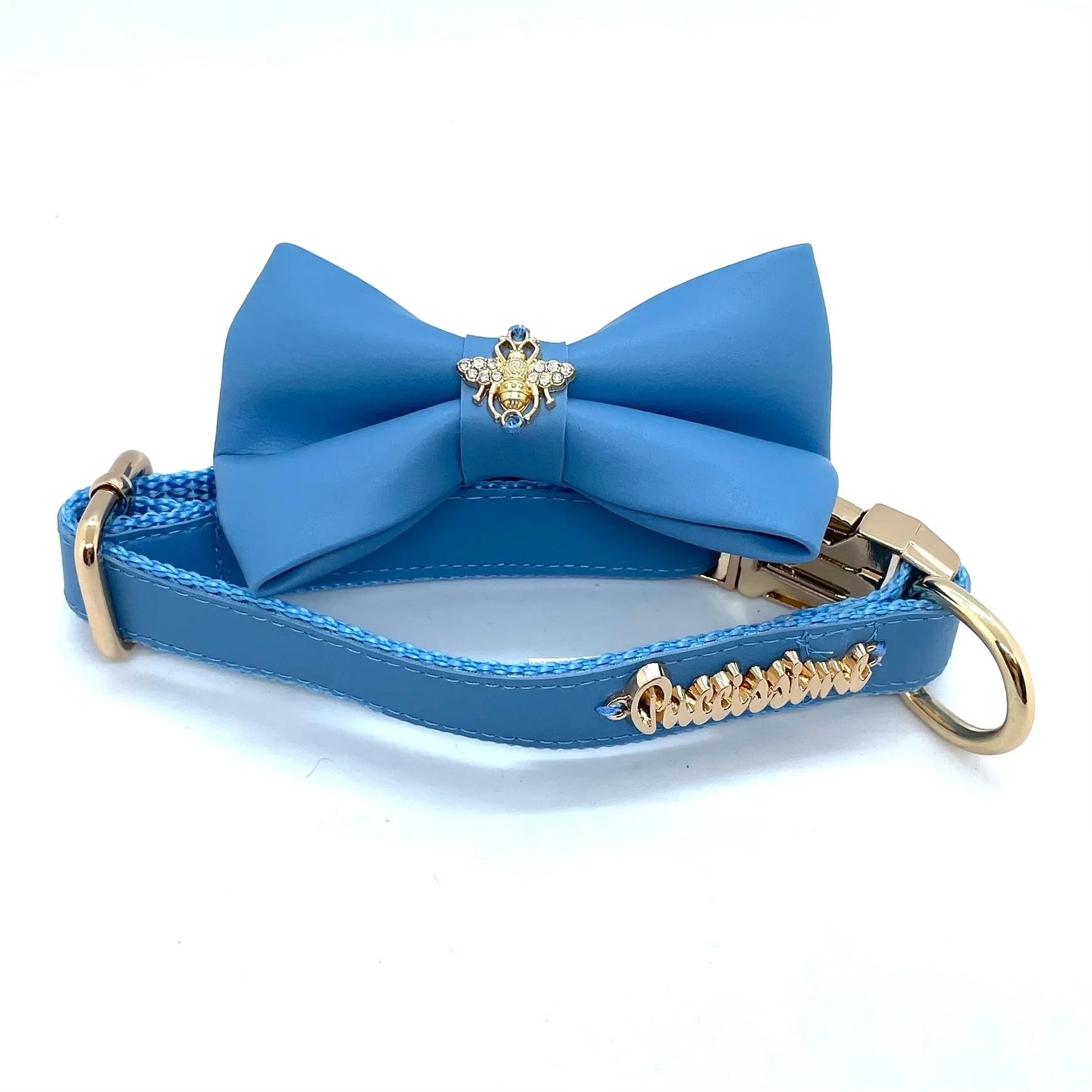 Blue dog collar with matching bow tie, gold bee brooch, and gold hardware on white background