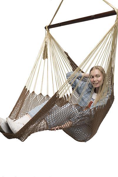 Woman relaxing in brown Mayan hammock chair with wooden bar on white background