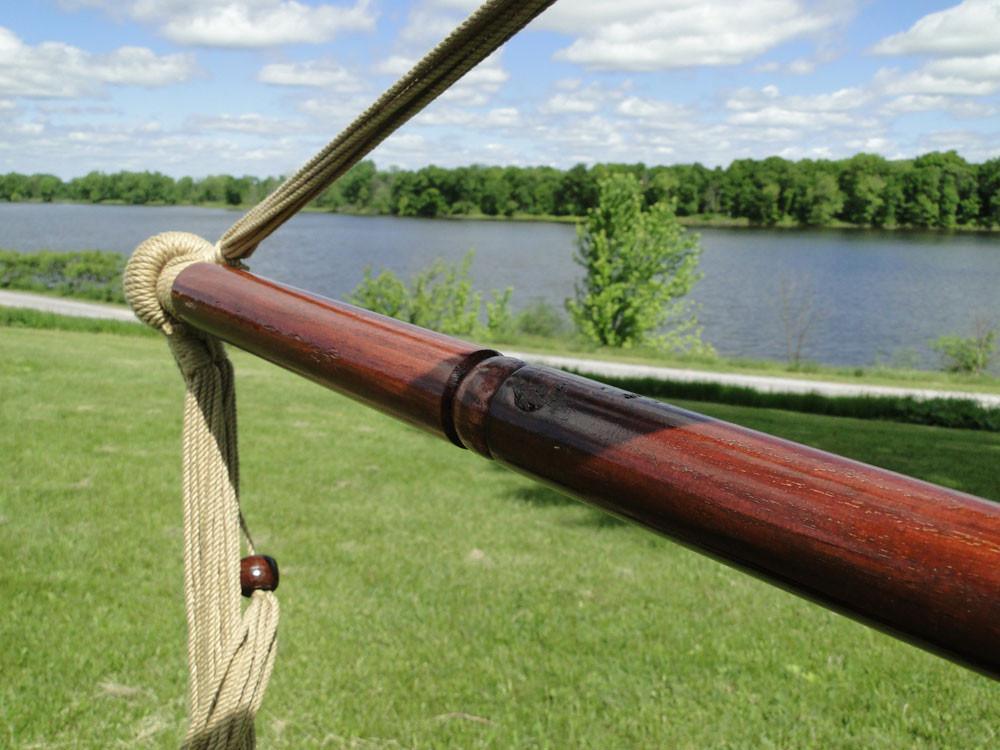 Mayan hammock chair wood bar with rope detail outdoors by a lake and green grass