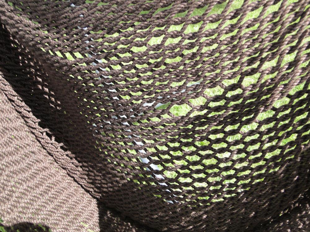 Close-up of brown Mayan hammock chair knit texture with green grass background