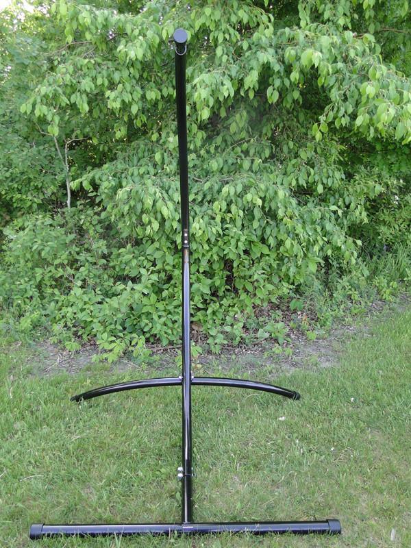 Black hammock chair stand on green grass with leafy trees in background outdoors