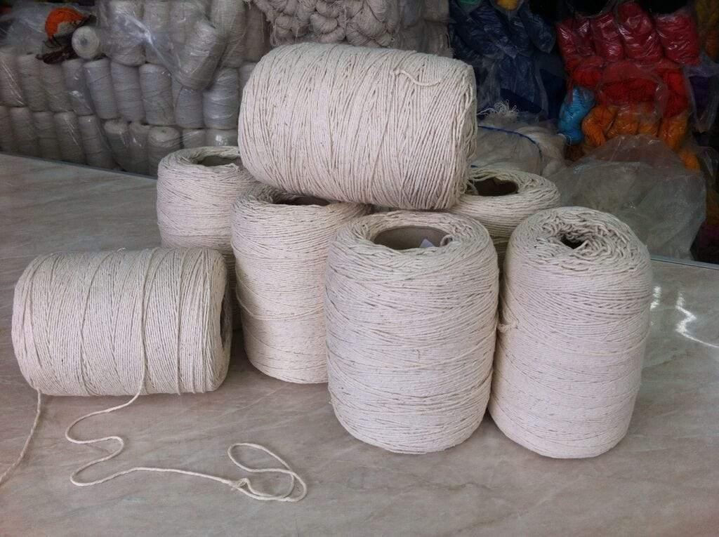 Natural cotton twine spools stacked on marble counter in textile shop
