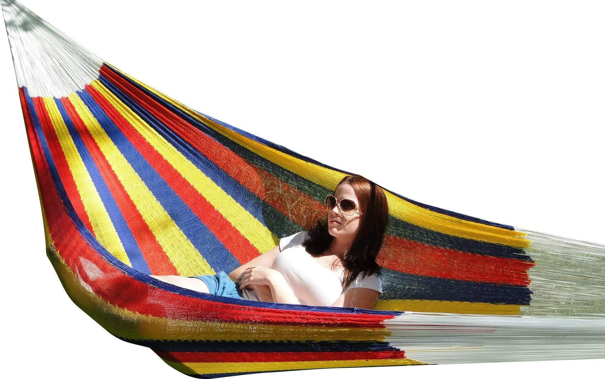 Woman relaxing in a colorful Mayan hammock double with red, yellow, and blue stripes