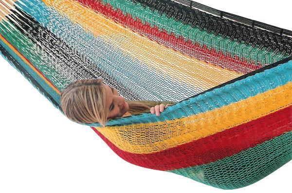 Woman relaxing in colorful XL family-sized Mayan hammock made of thick cord
