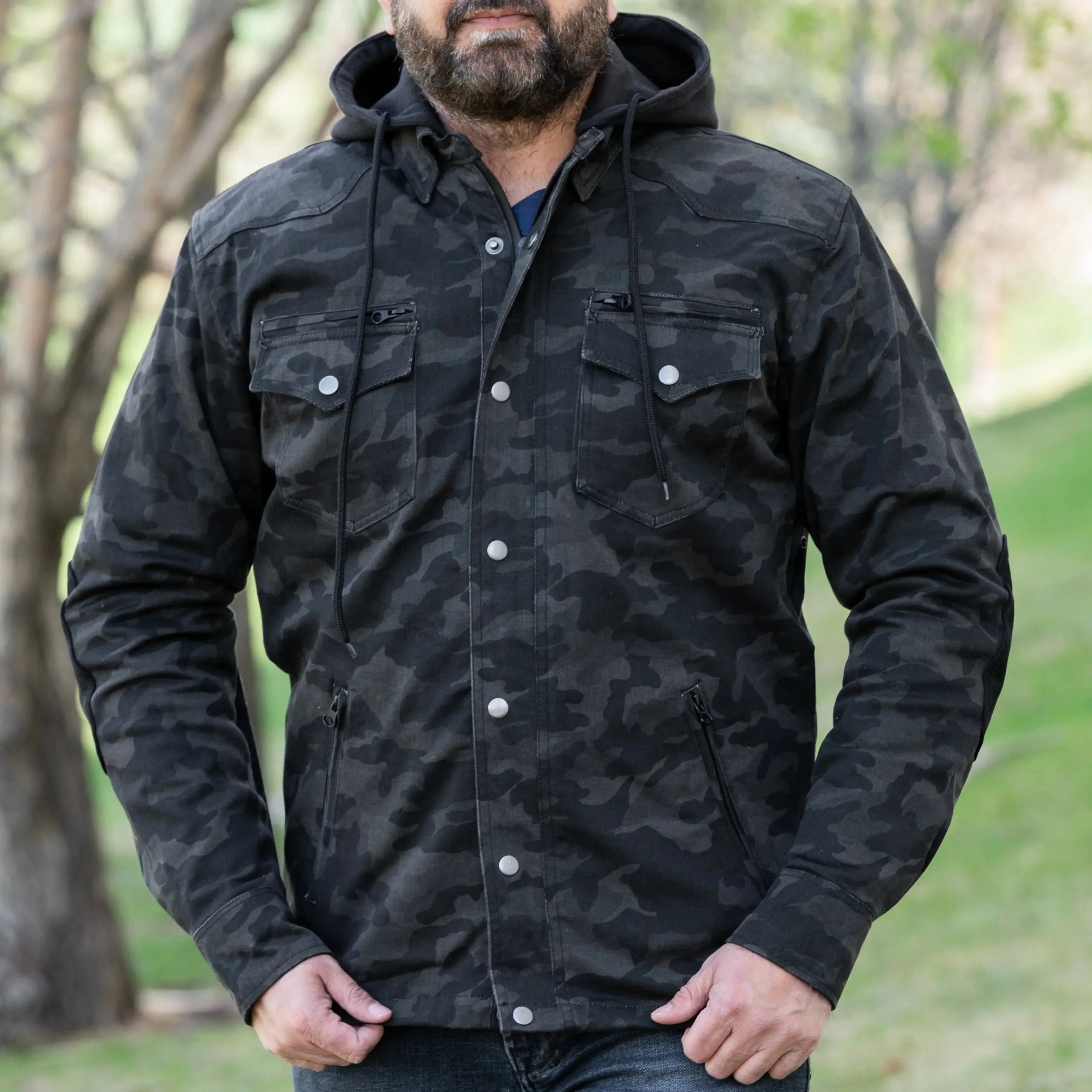 Man wearing black camo armored biker shirt with hood and chest pockets outdoors