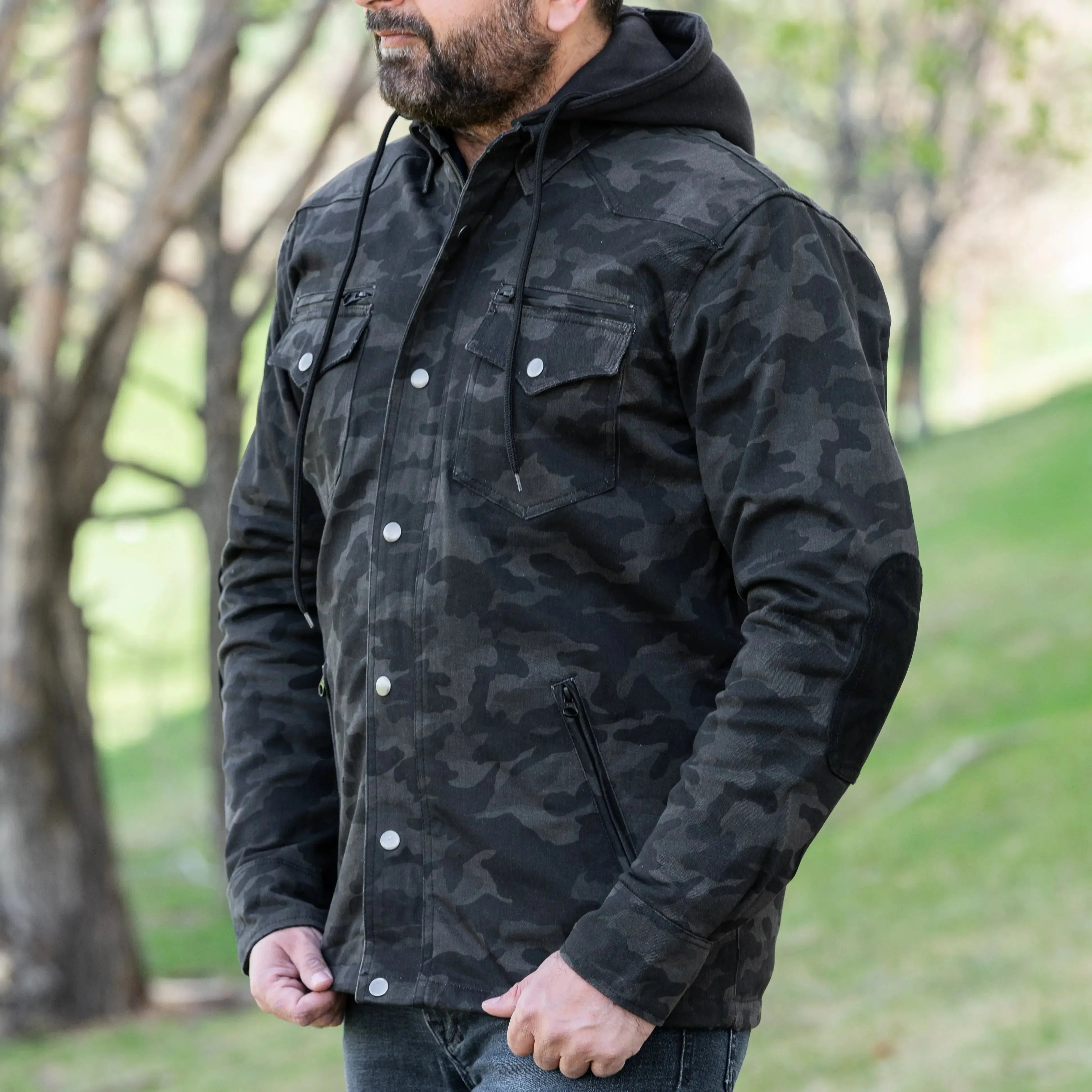 Man wearing black camo armored biker shirt with hood outdoors